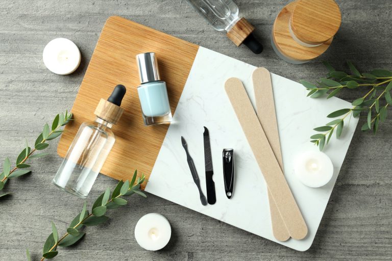Concept of nail care with manicure accessories on wooden backgro